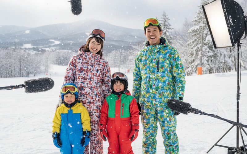北海道の雪景色を背景に笑顔で質問に答える家族