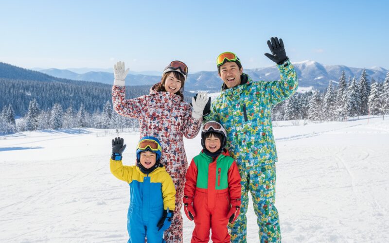 北海道の雪景色の中で笑顔で手を振る子連れ家族